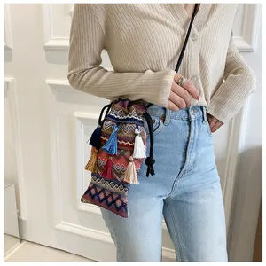 Sac bandoulière seau tissé de style ethnique bohème avec des glands colorés pour femmes.