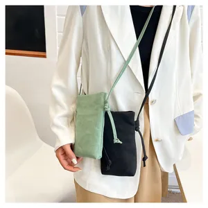 Détail de sac bandoulière en toile avec cordon de serrage et deux coloris pratiques.