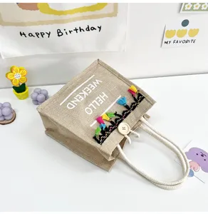 Sac cabas en lin chic avec des pompons colores et un bouton en bois pour un look quotidien.