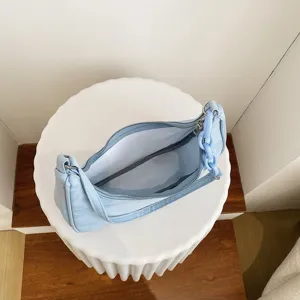 Sac a main sous-bras en nylon bleu clair, details de chaine acrylique et fermeture.