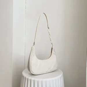 Gros plan détaillé du sac porté épaule minimaliste en nylon avec chaîne acrylique chic.