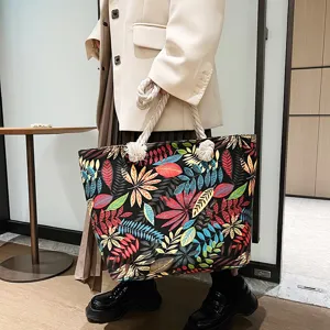 Detailansicht der lässigen Canvas-Tasche mit buntem Blätter-Druck und dicken Kordelgriffen.