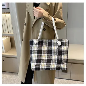 Detailaufnahme einer stilvollen schwarz-weißen Karomustertasche aus Wolle mit Henkeln.