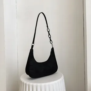 Sac à épaule noir en nylon sous les bras avec une très élégante chaîne en acrylique.