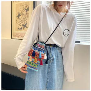 Sac bandoulière tissé style ethnique pour femmes, avec glands colorés et design seau unique.