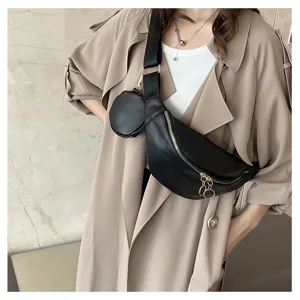 Sac bandoulière de poitrine en cuir PU noir avec petite pochette et fermetures éclair métalliques.