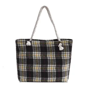 Detailansicht der karierten Tweed-Damentasche mit dickem Seilgriff und geräumigem Innenraum.