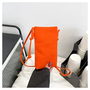 Détail de petit sac bandoulière orange pour téléphone, sacoche élégante pour les femmes.