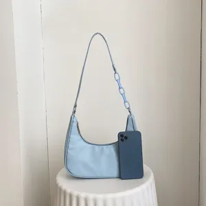Vue de détail du sac hobo en nylon bleu clair avec chaîne acrylique et tissu lisse.