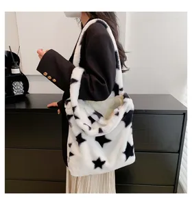 Detailed view of the fuzzy black and white star pattern plush shoulder tote bag fabric.