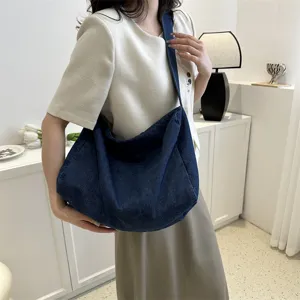 Sac bandoulière en denim décontracté pour femme, sac cabas souple et stylé au design simple.