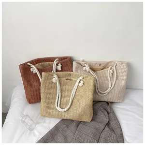 Detailansicht der Strohtasche mit stabilen Seilgriffen, lässiger Sommer-Strandstil.