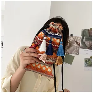 Sac seau tissé ethnique avec des glands colorés, vue détaillée montrant la texture et le design.