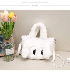 Detail de sac a main en peluche blanche douce avec design drole de grands yeux de dessin.