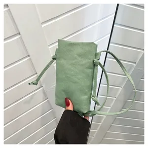 Vue détaillée du mini sac bandoulière en toile vert sauge avec de fines bretelles.