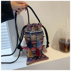 Vue détaillée du sac seau tissé ethnique bohème avec motifs colorés et glands multiples.