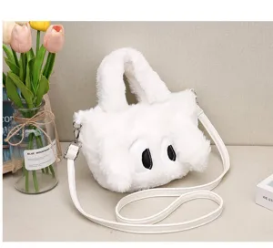 Détail du sac à main en peluche blanche avec des yeux de chien de dessin animé et texture douce.