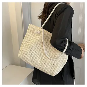 Sac cabas en paille beige avec anses en corde blanche, idéal pour l'été et la plage.