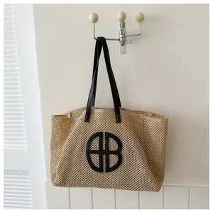 Large capacity woven straw beach bag with contrast shoulder straps and stylish monogram design.