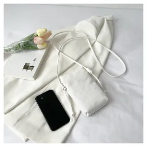 Vue détaillée du sac bandoulière blanc minimaliste, design élégant avec fine lanière.