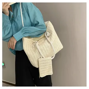 Détails du sac cabas en paille tissée élégante avec bandoulière et petite pochette assortie.