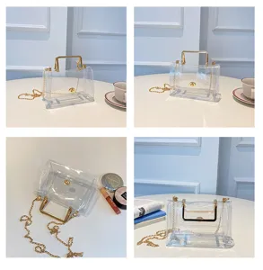 Vue détaillée du sac bandoulière transparent en PVC avec chaîne dorée sur table blanche.