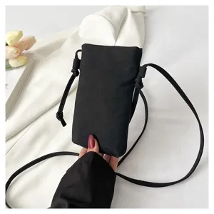 Détail de sac bandoulière noir minimaliste, pochette téléphone pratique pour femmes élégantes.