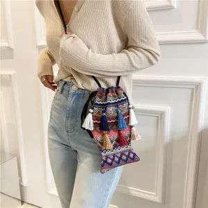 Sac bandoulière tissé ethnique élégant en forme de poisson avec des glands colorés.