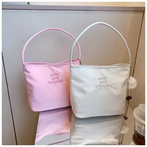 Vue détaillée de sacs bandoulière en nylon tendance rose et blanc avec broderie élégante.