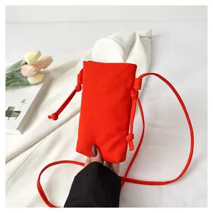 Vue détaillée du petit sac bandoulière de téléphone en toile rouge avec cordon et sangle.