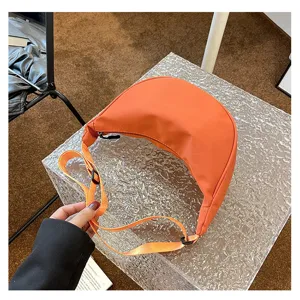 Detailansicht der orangen Nylon Halbmond Umhängetasche, zeigt Riemen und Textur.