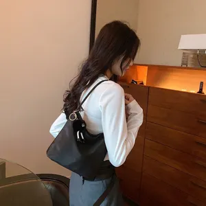 Sac épaule noir en nylon pour femme, sac seau sous les bras avec charm duveteux.
