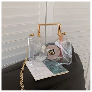 Sac transparent en PVC avec chaîne, détail sac bandoulière gelée avec poignée dorée.