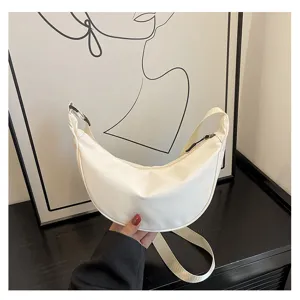 Detailaufnahme der weißen Nylon-Halbmond-Umhängetasche mit Reißverschluss und breitem Gurt.