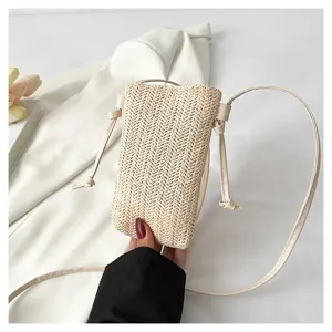 Vue de détail rapprochée du sac à bandoulière en paille tissée pour femme au style élégant.