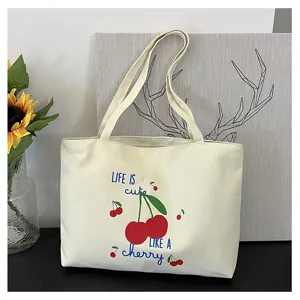 Canvas shopper detail met schattige kersenprint en Engelse tekst op crèmekleurige.