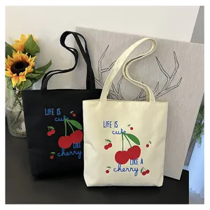 Gedetailleerd overzicht van de canvas tas met vrolijke kersenprint en dubbele schouderbanden.