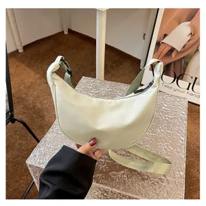 Detailansicht einer hellgrünen Nylon-Crescent-Umhängetasche mit Reißverschluss und Gurt.