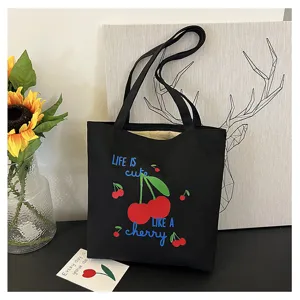 Gedetailleerd overzicht van de zwarte canvas tas met schattige kersenprint en schouderbanden.