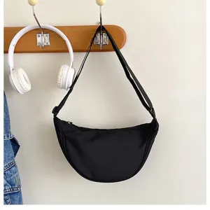 Sac porté épaule minimaliste en nylon noir, vue détaillée de sac croissant sous les bras.