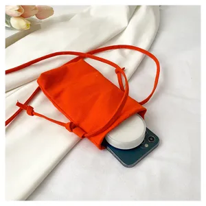 Mini sac bandoulière en toile orange mettant en valeur sa capacité compacte et son usage quotidien.