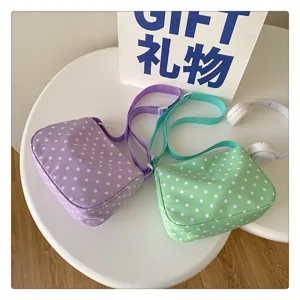 Gedetailleerd overzicht van nylon stippen crossbody tas in paars en groen met verstelbare riem.