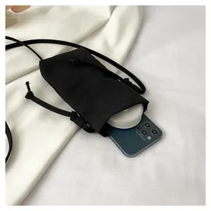 Vue détaillée du sac bandoulière noir en toile pour téléphone avec cordon réglable.