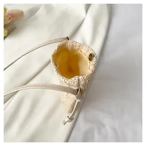 Gros plan détaillé de l'intérieur du sac en paille tressée avec doublure douce et sangle fine.