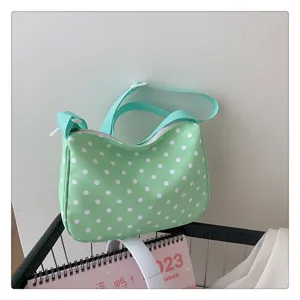 Gedetailleerd overzicht van de mintgroene nylon schoudertas met stippen en textuur.
