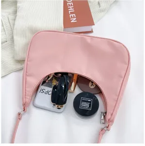 Sac sous les bras en nylon rose compact, vue détaillée montrant intérieur et accessoires.