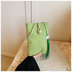 Primo piano dettaglio della borsa a tracolla verde in stile cinese con perla e nappa.