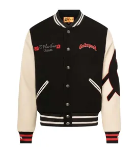 Black and white varsity jacket with embroidered letters and skull buttons, high street style.