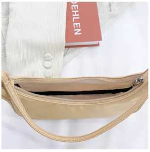 Vue détaillée de la fermeture éclair du sac en nylon beige avec une décoration simple.