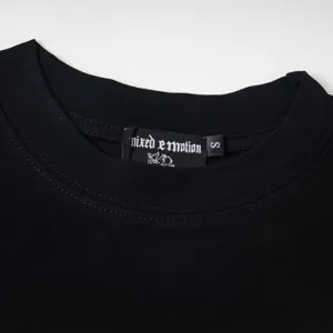 Vue rapprochée du détail du col du t-shirt à manches longues noir avec l'étiquette.